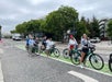 Tourists on bikes posing for a photo in the green bike lane on the streets of Santa Monica on a sunny day.