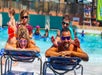 A mother and father laying out with their children sitting on them at Schlitterbahn New Braunfels in San Antonio, Texas.