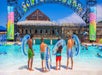 Four young guests holding their tubes and looking into the wave pool at Schlitterbahn New Braunfels in San Antonio.