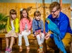 Kids watching a Macaw parrot.