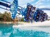 The Manta coaster full of people splashing into the water on a sunny day at SeaWorld in Orlando, Florida.