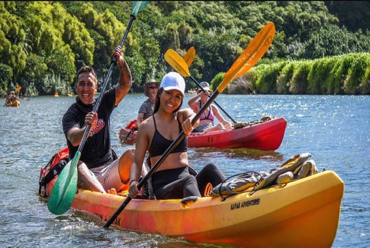 Guests are paddling in their bright yellow kayak in  the majestic Wailua River.