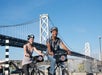 Couple biking near the Bay Bridge on the Self-Guided Bike Tour in San Francisco