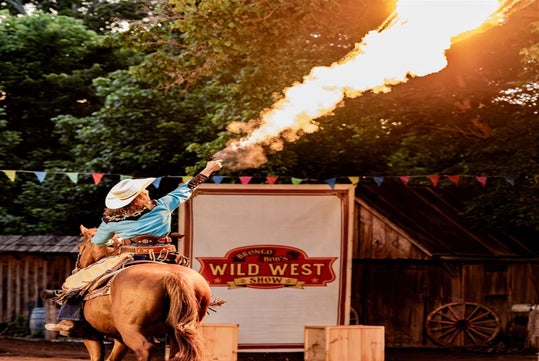A woman performs a horse-mounted shooting tricks.