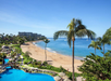 Beachfront resort surrounded by palm trees.