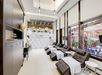 A spa lounge with reclining chairs, each draped with white blankets, surrounded by modern decor and a backdrop with "Signature" written on it.