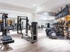 A modern gym with various exercise equipment, including treadmills, weight machines, and free weights, in a spacious, well-lit room.