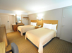 The room includes two queen beds, offering comfort and space for a relaxing stay.