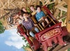 A group of people ride a wooden roller coaster at Silver Dollar City, smiling and holding on as the train goes through a banked turn.