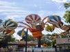 A view of the ride called Balloon Race where riders sit in large, colorful balloon-shaped vehicles that spin around a central point.