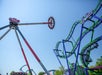 A large pendulum ride named Harley Quinn Spinsanity, with its gondola full of riders swung out to the side.
