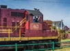 A train with a red engine car with the number 65 and the conductor on the train waving with Skunk Train in San Francisco, California, USA.