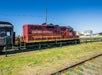The Skunk Train's red engine car with "California Western" on the side of it on a sunny day.