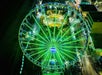 Aerial view looking down on the Myrtle Beach SkyWheel at night glowing a toxic green color.