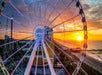 Aerial close up of the Myrtle Beach SkyWheel with a bright orange sun setting behind it.