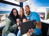 Three friends smiling and taking a selfie in the SkyWheel at Panama City Beach on a bright and sunny day with a blue sky behind them.