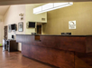 Hotel reception area with a wooden counter, two computer monitors, and a "Sleep Inn" sign on the wall.