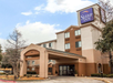Exterior view of a Sleep Inn hotel with a prominent entrance and trees around.