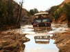 The Hummer H1 tackling a deep mud pit on the Slickrock Safari Hummer Adventure Tour in Moab Utah.