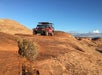 A beautiful view of the petrified sand dunes behind the Hummer H1 as it makes it way over some hills on the Slickrock Safari Hummer Adventure Tour in Moab Utah.