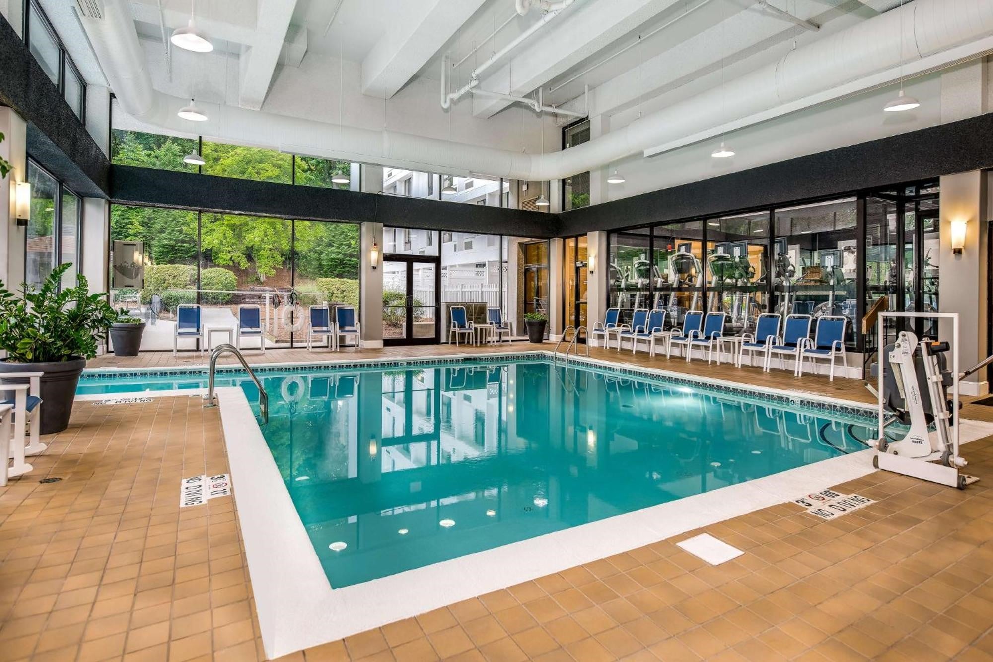 Sonesta Charlotte Lower South End indoor swimming pool with lounge chairs and floor-to-ceiling windows