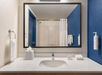 Private bathroom with mirror, sink, toiletries, and fresh towels.