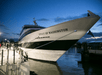Large yacht named "Spirit of Washington" docked by a waterfront at dusk, with people standing nearby.