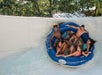 Five teenagers in a large blue tube going down a large white waterslide at Splish Splash Water Park.