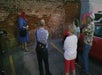 Four guests listen to the tour guide at a mysterious looking brick wall.