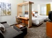 Suite with two queen beds, seating area with sofa bed, and work desk.
