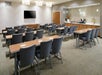 Meeting facility with tables, chairs and a flat-screen TV.