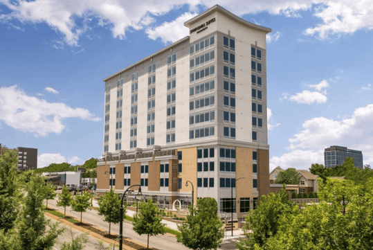 View of the front and side exterior of the SpringHill Suites by Marriott Atlanta Downtown on a bright and sunny day.