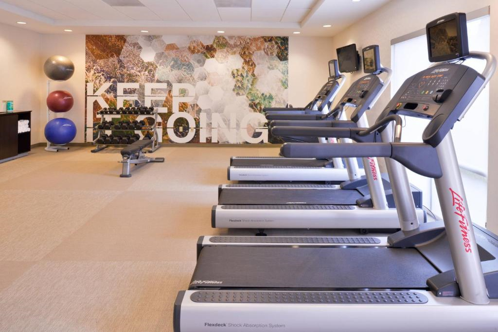 A gym with treadmills, exercise balls, and dumbbells. A mural on the wall reads "KEEP GOING.