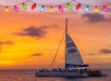 A sailboat with people on board cruises on the ocean at sunset, with colorful string lights hanging above.