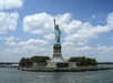 The Statue of Liberty on Liberty Island, with a partly cloudy sky and water in the foreground.
