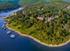 Aerial view of a wooded lakeside area with several buildings and docks along the shoreline.