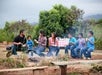A family sitting and eating in front of a fire at Gunstock Ranch Horseback Rides in Oahu - Kahuku, HI