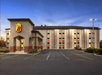 View of the front exterior of the Super 8 by Wyndham Mount Laurel with only one car in the parking lot and a dusty blue sunset overhead.