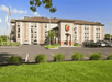 View of the front exterior of the Super 8 by Wyndham Mount Laurel  from the parking lot on a sunny day.