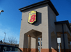 View looking up at the covered entrance of the Super 8 by Wyndham Mount Laurel with the sun shining on it and a blue sky behind it.