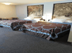 Two brown and blue queen beds with black and white art above them and a nightstand with lamp in between them in a room at the Super 8 by Wyndham.