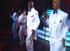 Four men in white suits and blue bow ties singing into microphones on stage at The Best of Motown and More in Branson, Missouri.