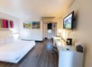 Guest room featuring one king bed, a convenient work desk, and a flat-screen TV.