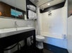 The bathroom features a sink, bath tub, shower and fresh towels.