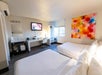 Guest room featuring two queen bed, a convenient work desk, and a flat-screen TV.