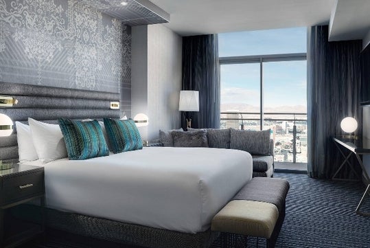 A hotel room with a large bed and a window.