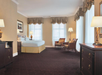 One king bed and a seating area with sofa and chairs.