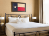 One king bed with white sheets inside a guest room.
