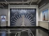 Art Deco-style wall mural features the Empire State Building with "Welcome" in various languages, set against a dark background in a modern hallway.
