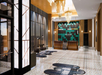 Modern hotel lobby with a check-in desk, stylish lighting, and contemporary decor featuring green and black wall art and patterned flooring.